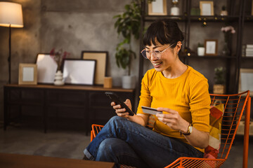 Japanese woman use credit card mobile phone online shopping at home