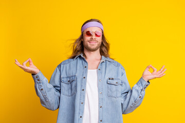 Portrait of cool young man meditate wear denim shirt isolated on yellow color background