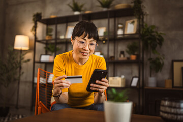 Japanese woman use credit card mobile phone online shopping at home