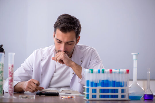 Young male chemist in front of white board