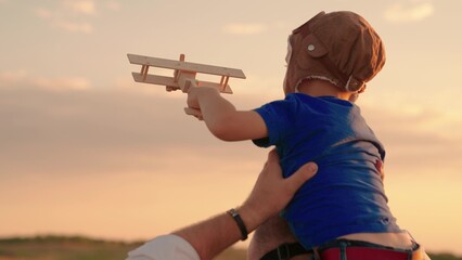 Dad plays with kid son is on his shoulders, child holds toy airplane in his hand, dreams of becoming an airplane pilot. Happy family. Little son, kid with dad, fun weekend trip with kid. Kid dream fly