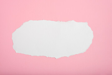 Torn white paper on pink paper background. Blank space for text.