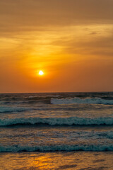 picturesque sunset at seaside with an orange cloudy sky in details.