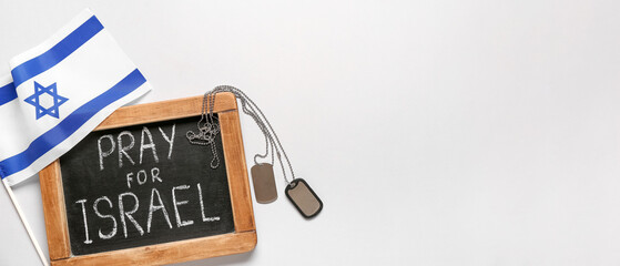 Chalkboard with text PRAY FOR ISRAEL, flag and dog tags on white background
