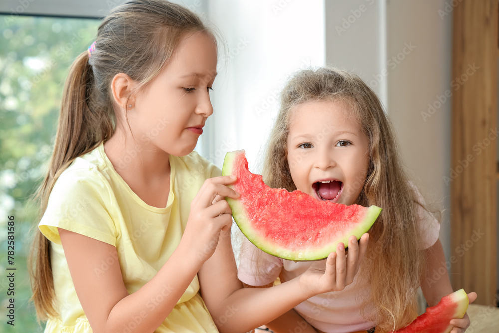 Sticker Happy little girls eating fresh watermelon in kitchen