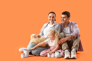 Happy family with paint cans sitting on orange background