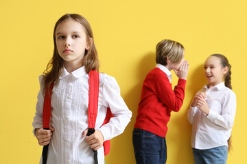 Bullied little girl and her classmates on yellow background - obrazy, fototapety, plakaty