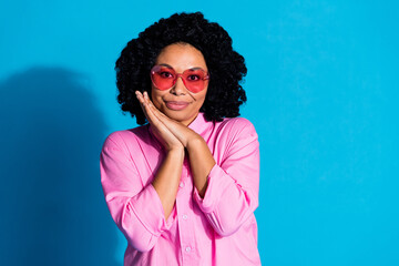 Fototapeta premium Portrait of pretty young woman arms under cheek empty space wear pink shirt isolated on blue color background