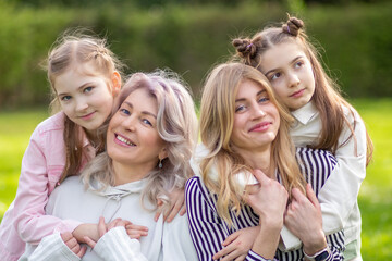 Fototapeta premium Happy family outdoors: mother, grandmother, and daughter.
