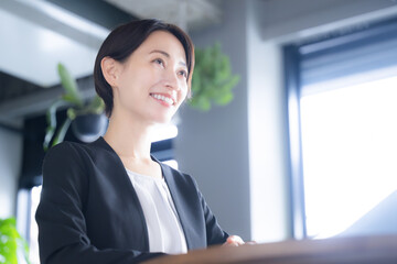 Image of a smiling woman in a meeting or business meeting saleswoman Image of real estate, consultant, etc. - obrazy, fototapety, plakaty