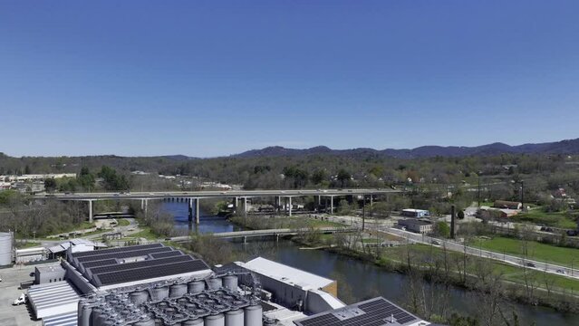 Aerial Drone Footage of Downtown Asheville North Carolina on a sunny spring day with the Appalachian Mountains and a bright blue sky in the background