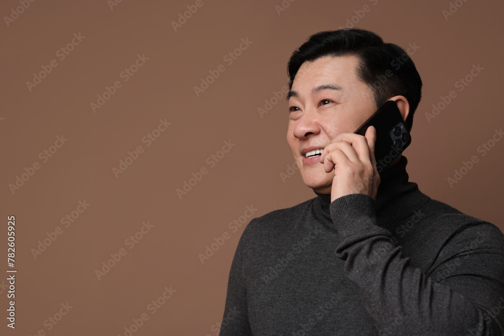 Poster Portrait of happy man with smartphone on brown background. Space for text