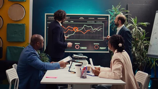 Marketing team attending a tensed meeting to review sales trends on interactive board, looking for ways to increase the organization profit and ensure global success. PR specialists. Camera B.