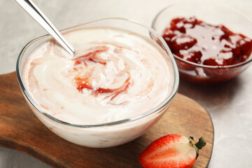 Tasty yoghurt with jam and strawberry on grey table, closeup