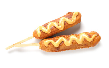 Tasty corn dogs with mustard on white background