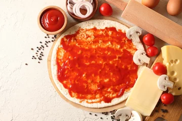 Fotobehang Pizza base smeared with tomato sauce, peppercorns and products on light textured table, flat lay © New Africa
