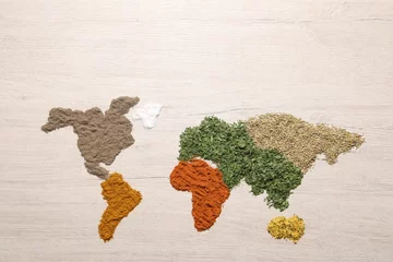 Fotobehang World map of different spices on wooden table, flat lay © New Africa