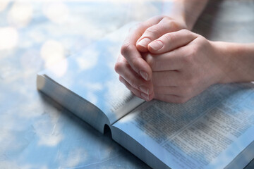 Religion. Double exposure of sky and Christian woman praying over Bible at table, closeup. Bokeh effect