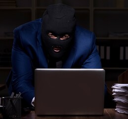 Male employee stealing information in the office night time