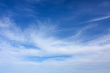 Tranquil blue sky with scattered white clouds, serene atmosphere for design projects. Ideal for backgrounds, websites, presentations, promoting peace, mindfulness, nature.