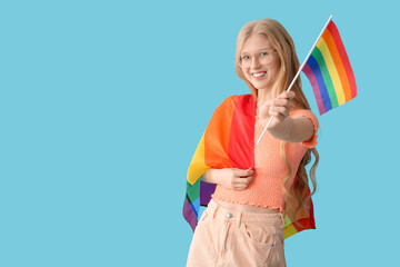 Beautiful young happy woman with LGBT flags on blue background