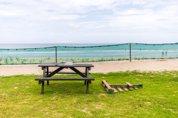 A Table Positioned in Front of a Fence Against a Blurry Ocean Background