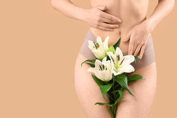 Beautiful young woman in underwear with white lily flowers on beige background, closeup