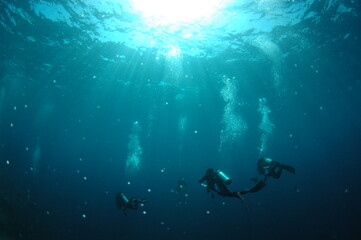 泡をあげて深海を潜るダイバー