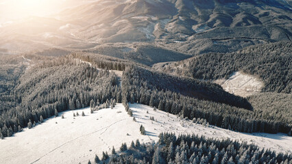 Aerial sunrise at snow mountain resort. Sun ski slope for tourist active sport. Winter nobody...