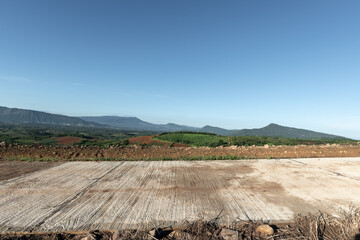 Side view of concrete road in countryside with mountains. - 782650701