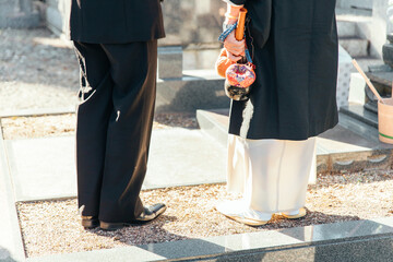お墓・墓地・霊園で納骨式をする日本人の遺族と住職

