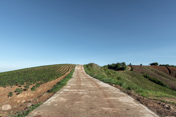 Concrete road in countryside with mountains.