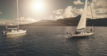 Sun over sailing regatta on luxury yachts aerial. Cinematic seascape of yachting summer sunny day....