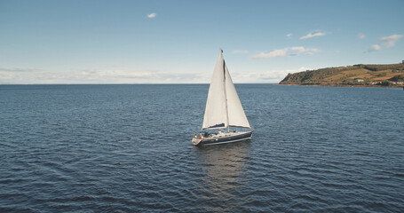 Slow motion aerial of yacht sail. Sun reflect at sea water. Nobody nature seascape. Sport and...