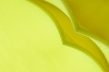 thin sheet of yellow sponge foam. curved fold detail. polyurethane foam texture. - obrazy, fototapety, plakaty