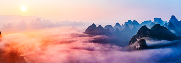 Panorama of sea of clouds around mountain peaks at sunrise. Famous karst mountain natural landscape in Guilin.