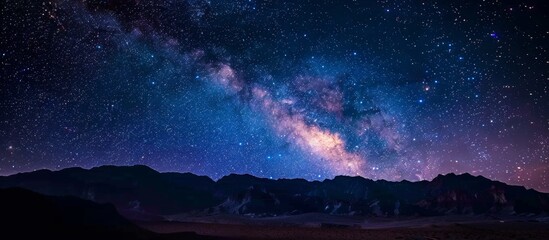 Dark night sky dotted with countless stars and a faint band of the milky way stretching across the horizon - obrazy, fototapety, plakaty