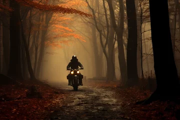 Foto auf Glas A biker riding through an enchanting forest in autumn © KerXing