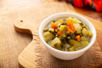 Homemade fresh vegetable soup, easy recipe made with chopped vegetables, carrot, celery, pumpkin, spinach, chayote and other ingredients, healthy dish popular in many countries.