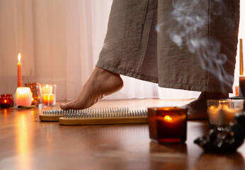  woman legs  with nail board and burning candles - 782720345