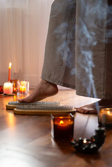 woman legs  with nail board and burning candles