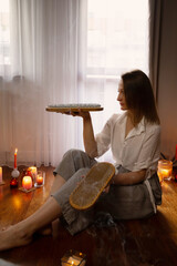 young woman indoor with nail board and burning candles - 782720363