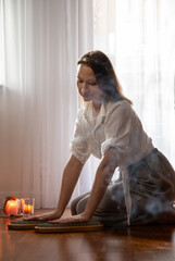 young woman indoor with nail board and burning candles - 782720383