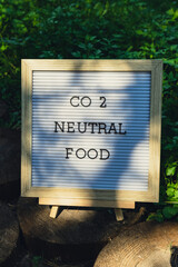 CO2 NEUTRAL FOOD message on background of fresh eco-friendly bio grown green herb parsley in garden. Countryside food production concept. Locally produce harvesting. Sustainability