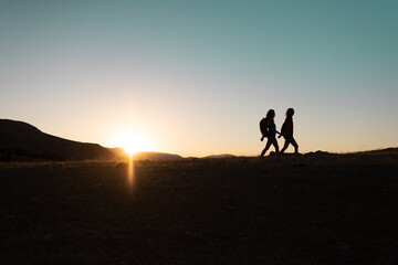 two people walk along a mountain range - 782725739