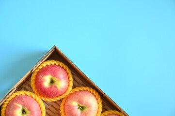 beautiful pink apple in the box on blue background - 782729384