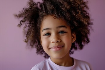Close up portrait of a cute african american little girl with curly hair on a purple background