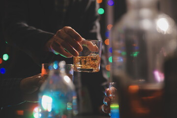 Fototapeta na wymiar Celebration night, pour whiskey into a glass. Give to friends who come to celebrate