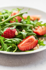 Fresh Strawberry Arugula Salad With Pine Nuts Served on a Bright Day