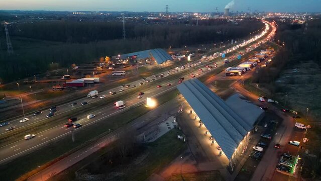 Captured at twilight, this aerial footage shows the dynamic flow of evening traffic on a busy highway overpass. Headlights and tail lights create a luminous dance of movement, reflecting the pulse of